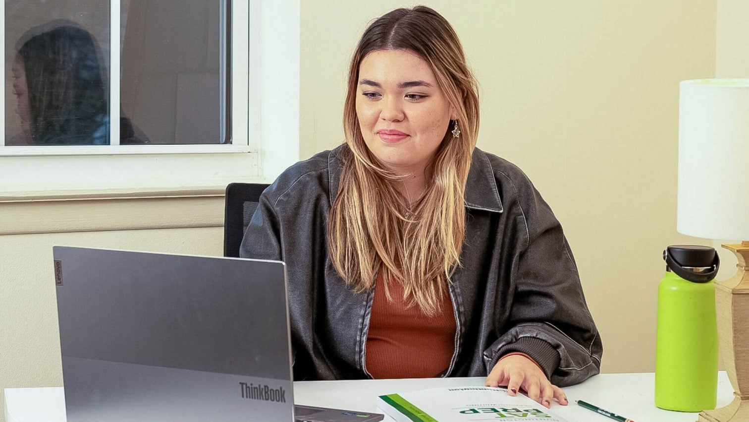 A young girl writes answers on a worksheet. The Wyoming Department of Education logo and name, highlighting the Equal Opportunity for Students with Special Needs Act, are displayed above her in the background.