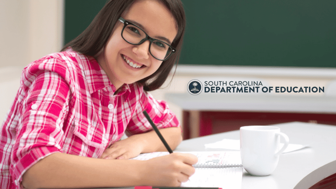 A smiling student wearing glasses and a pink plaid shirt writes in a notebook at a desk with a white mug, representing the opportunities offered by the Education Freedom Account. The South Carolina Department of Education logo appears in the background.