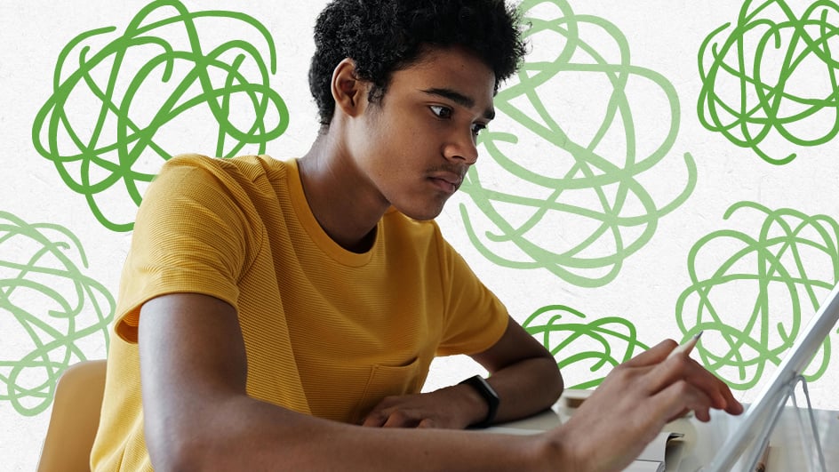 Young boy doing school work on a tablet at desk