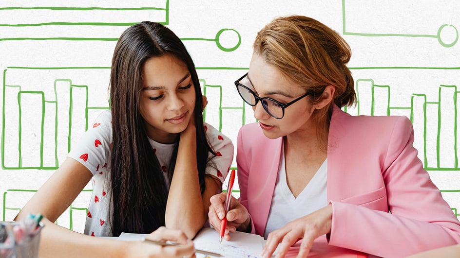 Teacher and student reviewing school work together at desk