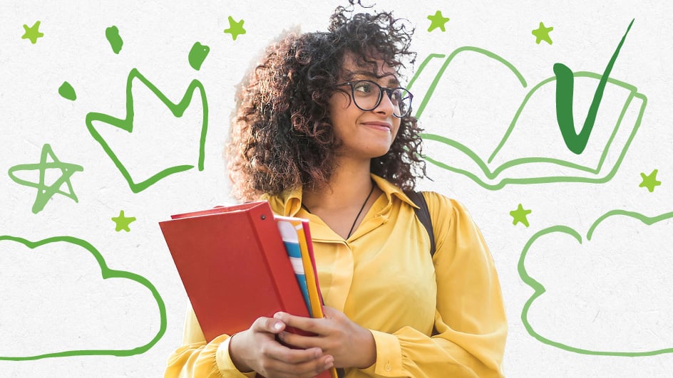 Student holding books smiling walking outside
